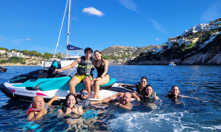Un grupo de personas disfrutando en el agua junto a una moto de agua.