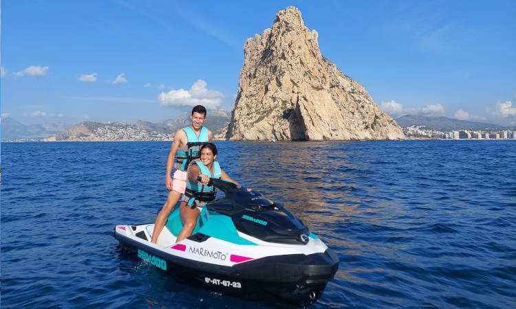 Pareja posando en moto de agua con el Peñón de Ifach al fondo.